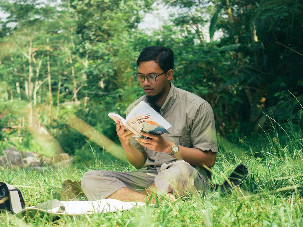 Iemand leest een boek in het gras